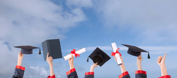 istock graduation ceremony hats  and hands up with sunny sky 1147436027