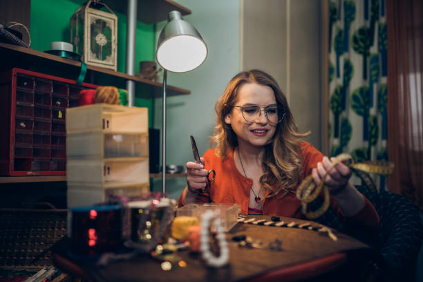 istock Smiling woman using tools and making fashion jewelry 1147439577