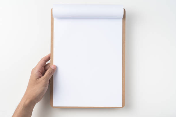 white flipped paper on clipboard isolated on white Design concept - top view of man hand hold white A4 flipped paper on brown clipboard isolated on white background for mockup. real photo, not 3D render clipboard stock pictures, royalty-free photos & images