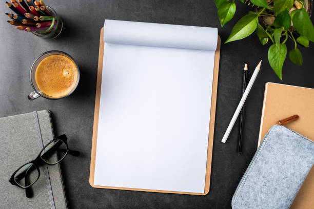 white paper with clipboard on black background Design concept - top view of copy space with A4 paper, potted plant, glasses, coffee, pencil on black background for mockup. real photo, not 3D render potted plant from above stock pictures, royalty-free photos & images