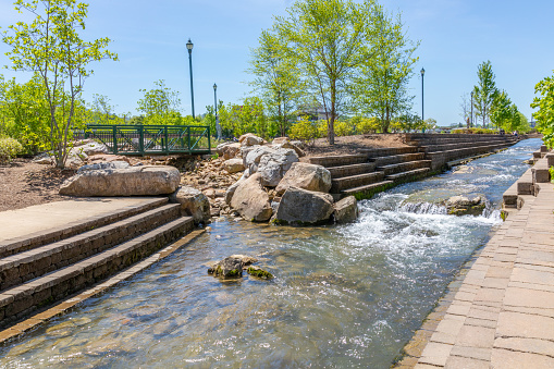 Johnson City, TN, USA-4/27/19: Masonry steps on both sides of stream flowing through Founders' Park in downtown.