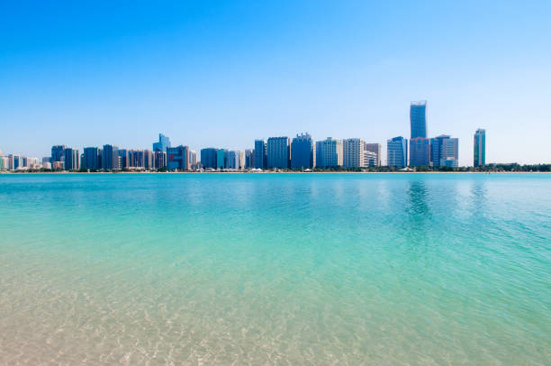istock Sand beach blue sea with Abu Dhabi skyline and modern buildings 1147449416