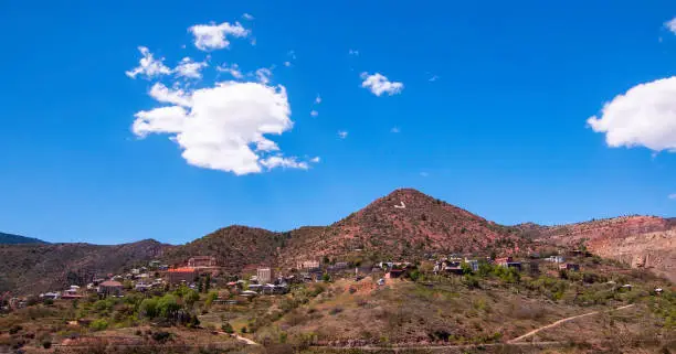 Jerome, Arizona, USA seen in the distance under bright blue skies with white clouds