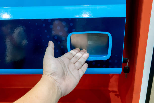 istock Man hand waiting for snack from snack vending machine against red background. 1147454215