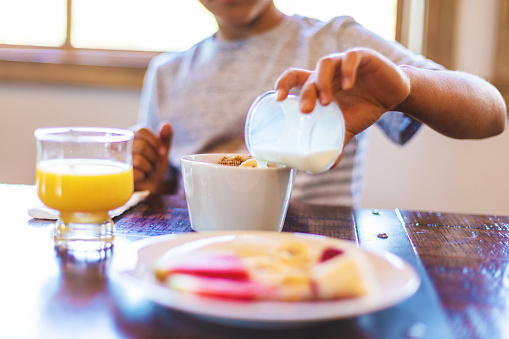 Young Boy Eating Breakfast Cereal with Complementing Fruit and healthy Additions and Beverages Photographed with Social Media Cropping in Mind (Shot with Canon 5DS 50.6mp photos professionally retouched - Lightroom / Photoshop - original size 5792 x 8688)