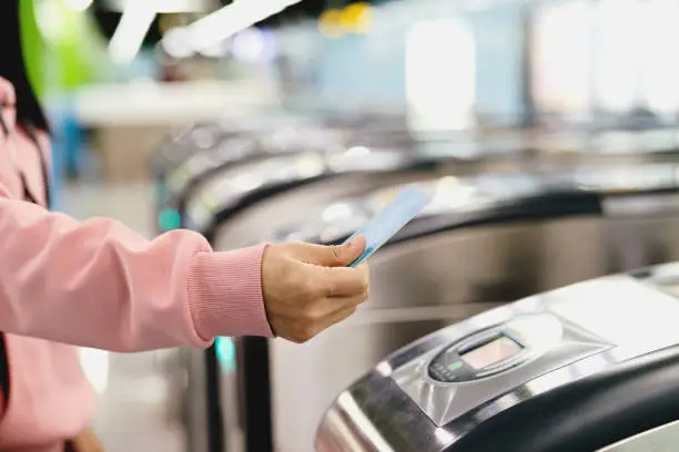 Woman hand scanning train ticket to subway entrance gate. Transportation concept