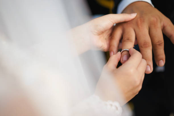 istock Bride putting on a wedding ring for bridegroom 1147466890