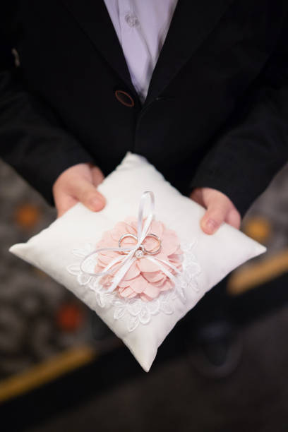 Little boy holding wedding rings on pillow