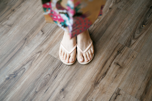 Lady in floral dress wearing slippers