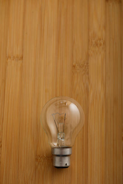 istock bulb with green leaf on wooden background 1147467204