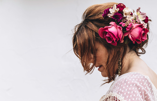 Beauty shot of a flamenco dancer with nice hairstyle and flowers in her hair on white background. April fair 2019 Seville