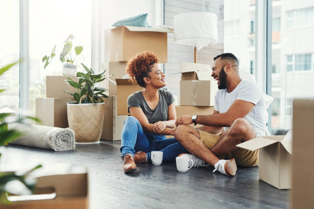 Creating lasting memories in their new nest Shot of a young couple taking a break while moving house young couple stock pictures, royalty-free photos & images