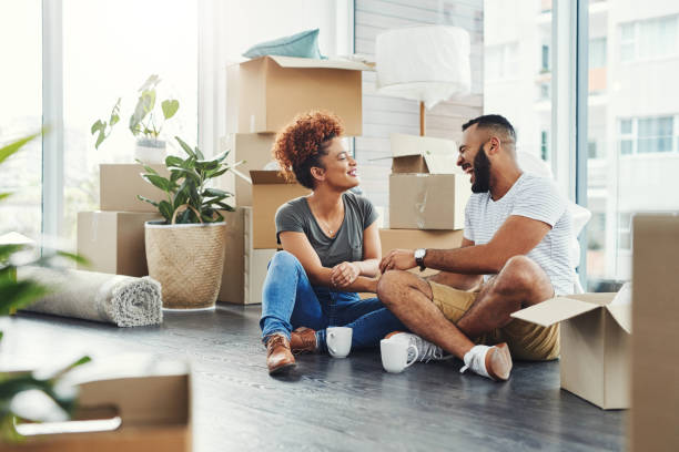 Creating lasting memories in their new nest Shot of a young couple taking a break while moving house sitting on floor stock pictures, royalty-free photos & images