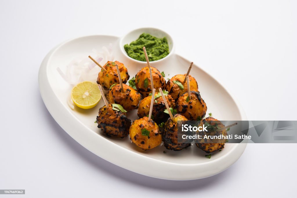 Tandoori aloo are roasted potatoes with Indian spices. It's a party appetiser served with green chutney. selective focus Appetizer Stock Photo