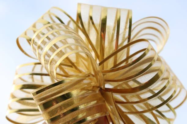 istock gold bow close-up on blue or wooden background 1147469499
