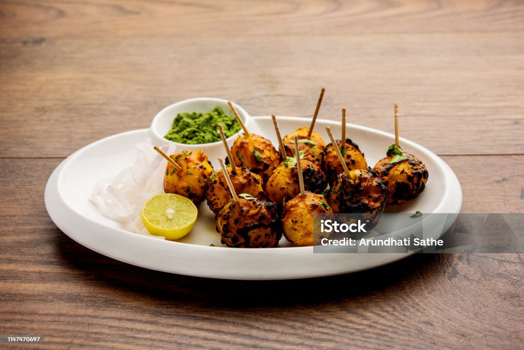 Tandoori aloo are roasted potatoes with Indian spices. It's a party appetiser served with green chutney. selective focus Appetizer Stock Photo