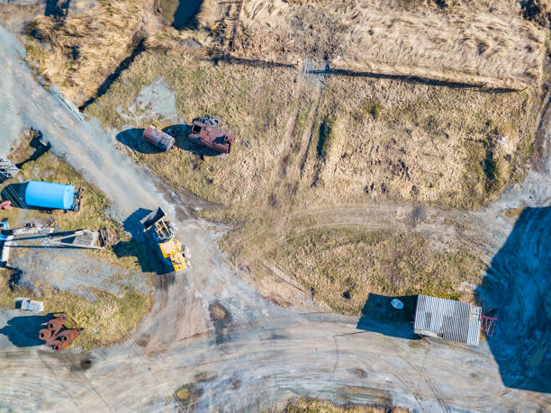 掘削機と黄色のトラクターの空中ビューは晴れた日に道路や建物の建設のために地球からの鉱物の抽出中に砕石、セメントや砂を輸送します。 - earth mover working field dirt ストックフォトと画像