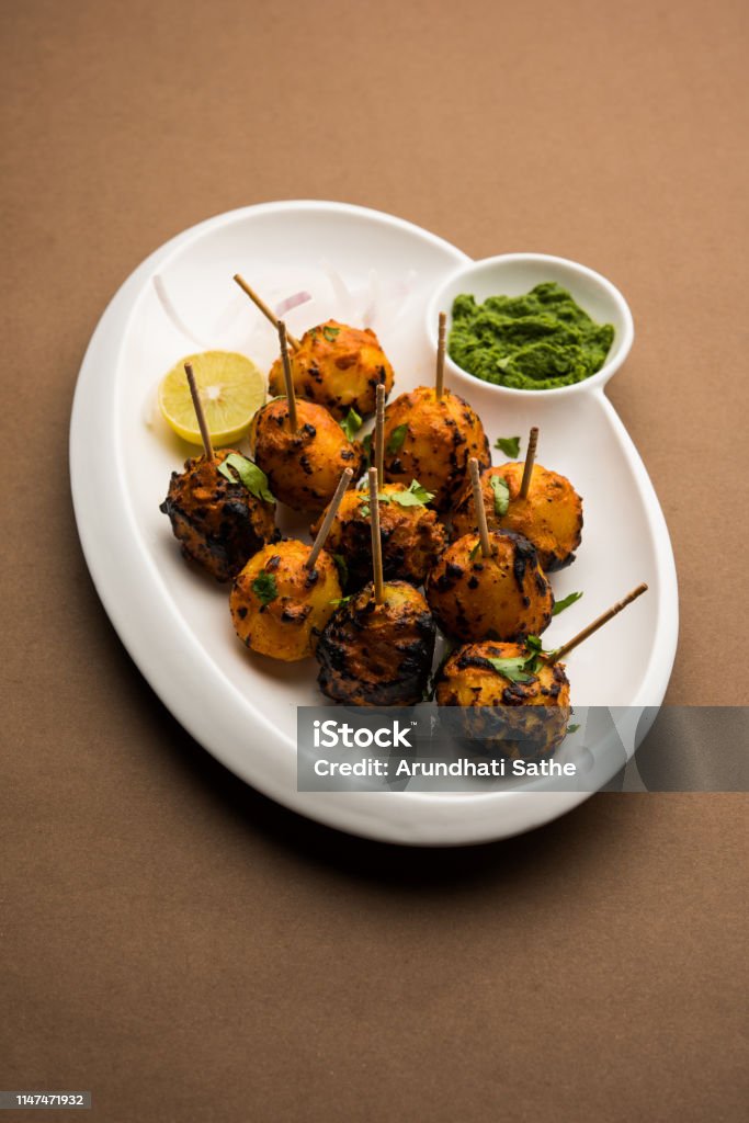 Tandoori aloo are roasted potatoes with Indian spices. It's a party appetiser served with green chutney. selective focus Tandoori Stock Photo