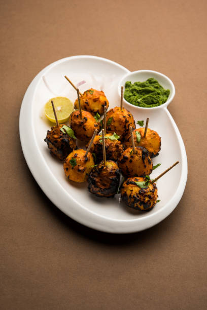 Tandoori aloo are roasted potatoes with Indian spices. It's a party appetiser served with green chutney. selective focus Tandoori aloo are roasted potatoes with Indian spices. It's a party appetiser served with green chutney. selective focus appetiser stock pictures, royalty-free photos & images