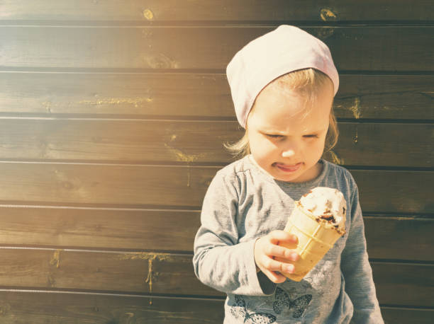 istock child with ice cream in hand on wooden background with copy space 1147472158