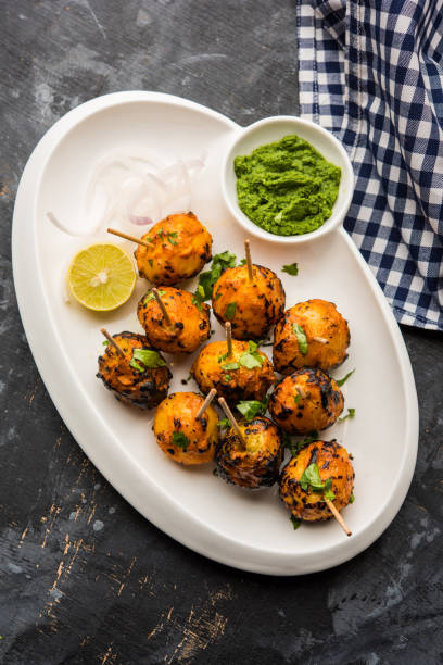 Tandoori aloo are roasted potatoes with Indian spices. It's a party appetiser served with green chutney. selective focus Tandoori aloo are roasted potatoes with Indian spices. It's a party appetiser served with green chutney. selective focus appetiser stock pictures, royalty-free photos & images