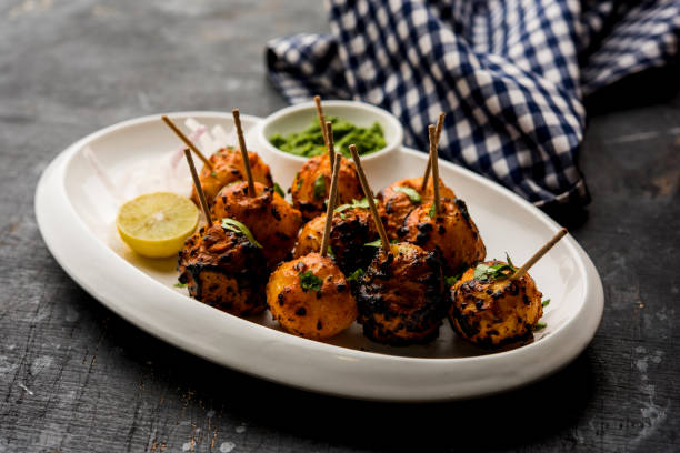 Tandoori aloo are roasted potatoes with Indian spices. It's a party appetiser served with green chutney. selective focus Tandoori aloo are roasted potatoes with Indian spices. It's a party appetiser served with green chutney. selective focus appetiser stock pictures, royalty-free photos & images