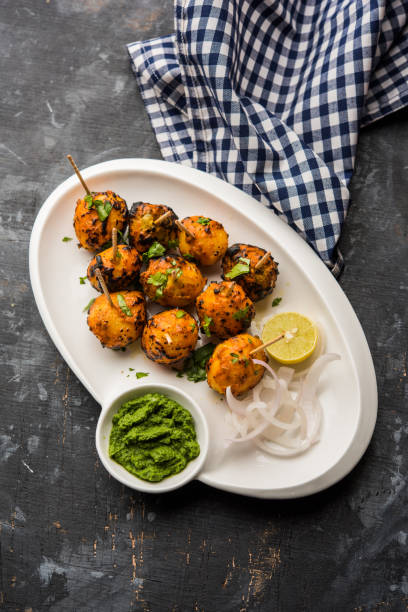 Tandoori aloo are roasted potatoes with Indian spices. It's a party appetiser served with green chutney. selective focus Tandoori aloo are roasted potatoes with Indian spices. It's a party appetiser served with green chutney. selective focus appetiser stock pictures, royalty-free photos & images