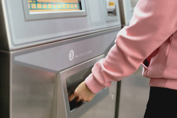 istock Woman take a train ticket after buy from subway ticket machine. Transportation concept 1147473433
