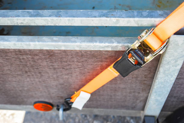 istock Trailer strop or strap in orange nylon and metal, object helping for holding stuff , storage and transport for safty and security. 1147475993