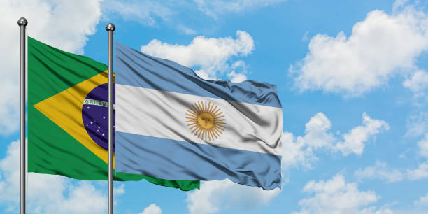 Brazil and Argentina flag waving in the wind against white cloudy blue sky together. Diplomacy concept, international relations. Brazil and Argentina flag waving in the wind against white cloudy blue sky together. Diplomacy concept, international relations. consul photos stock pictures, royalty-free photos & images
