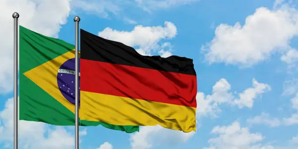 Brazil and Germany flag waving in the wind against white cloudy blue sky together. Diplomacy concept, international relations.