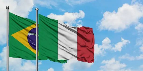 Brazil and Italy flag waving in the wind against white cloudy blue sky together. Diplomacy concept, international relations.