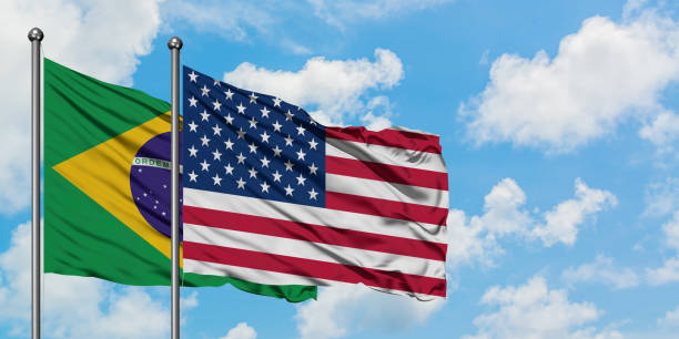 Brazil and United States flag waving in the wind against white cloudy blue sky together. Diplomacy concept, international relations. Brazil and United States flag waving in the wind against white cloudy blue sky together. Diplomacy concept, international relations. consul photos stock pictures, royalty-free photos & images