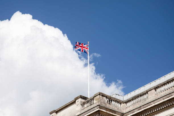 istock British flag on a mast, cloudy sky in background 1147478152