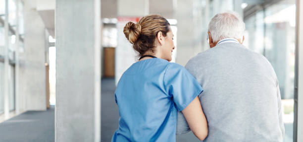 Making sure he gets his daily exercise Shot of a female nurse assisting her senior patient while walking doctor lifestyle stock pictures, royalty-free photos & images