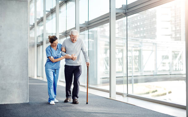 Seniors always need someone to lean on Shot of a female nurse assisting her senior patient while walking walking stick stock pictures, royalty-free photos & images