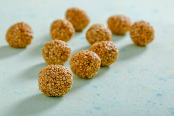 pila de tilgul laddu hecho a mano, semillas de sésamo para el festival makar sankranti, - peanut bowl nut circle fotografías e imágenes de stock