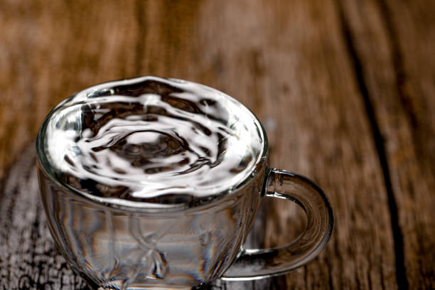 water in cup on wooden background
