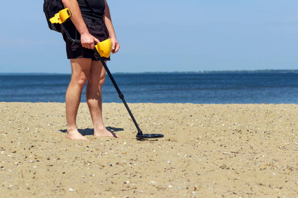 istock man with metal detector on the beach 1147484086