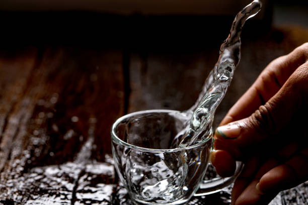 istock water in cup on wooden background 1147490672