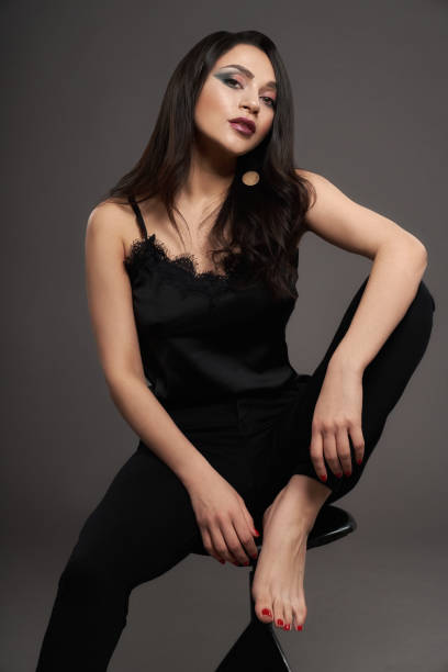 istock Brunette in black stylish blouse posing barefoot. 1147495911