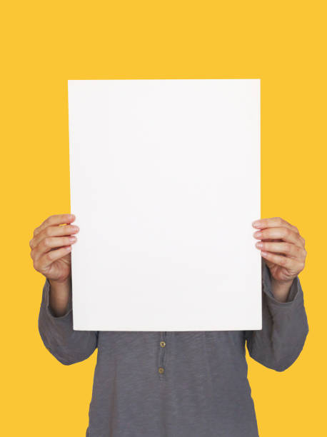istock woman's hands holding white paper poster on orange background 1147496067