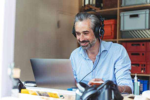 istock creative man with headphones working at laptop in homeoffice 1147501050