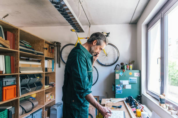 istock handsome craftsmen in overall talling about project at mobile 1147502213