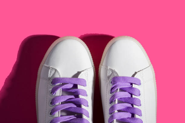 istock White sneakers with purple laces on bold pink 1147502965