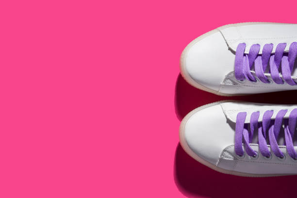 istock White sneakers with purple laces on bold pink 1147502972