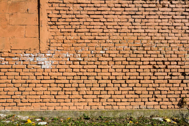 istock Old yellow brick wall part painted in brown 1147505257