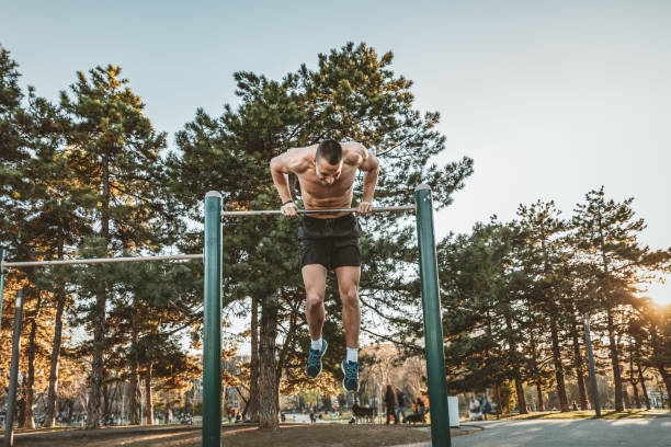 istock Handsome Young Athlete Doing Chin-ups on Horizontal Bar 1147506436