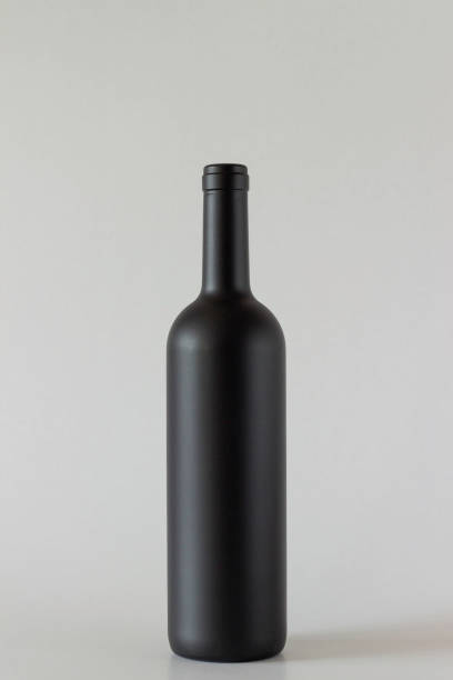 istock Black bottle of wine on a grey background. 1147508929