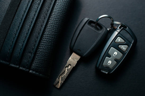 istock Black leather wallet with car key on a black background 1147510338